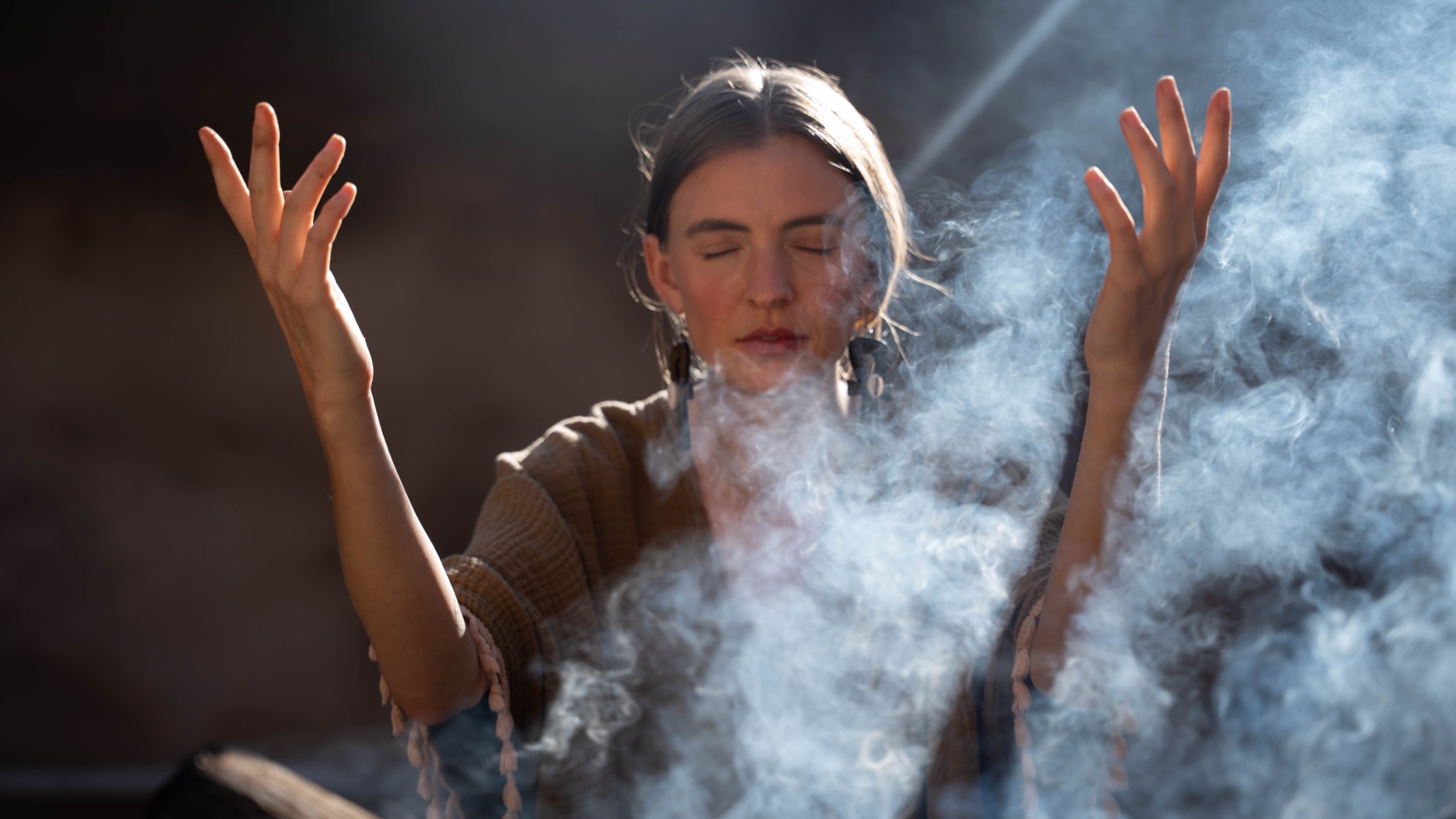 Bliss with hands raised in rising smoke